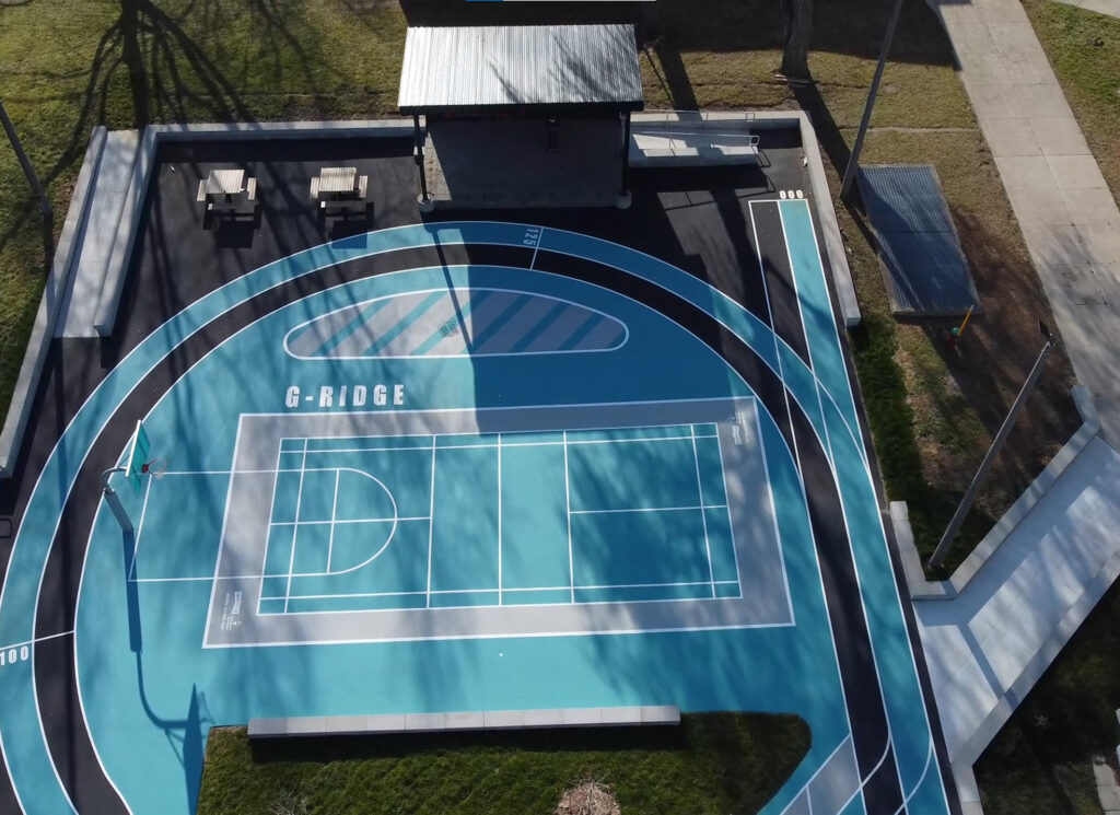 Gordonridge's court with basketball nets, seating and storage.