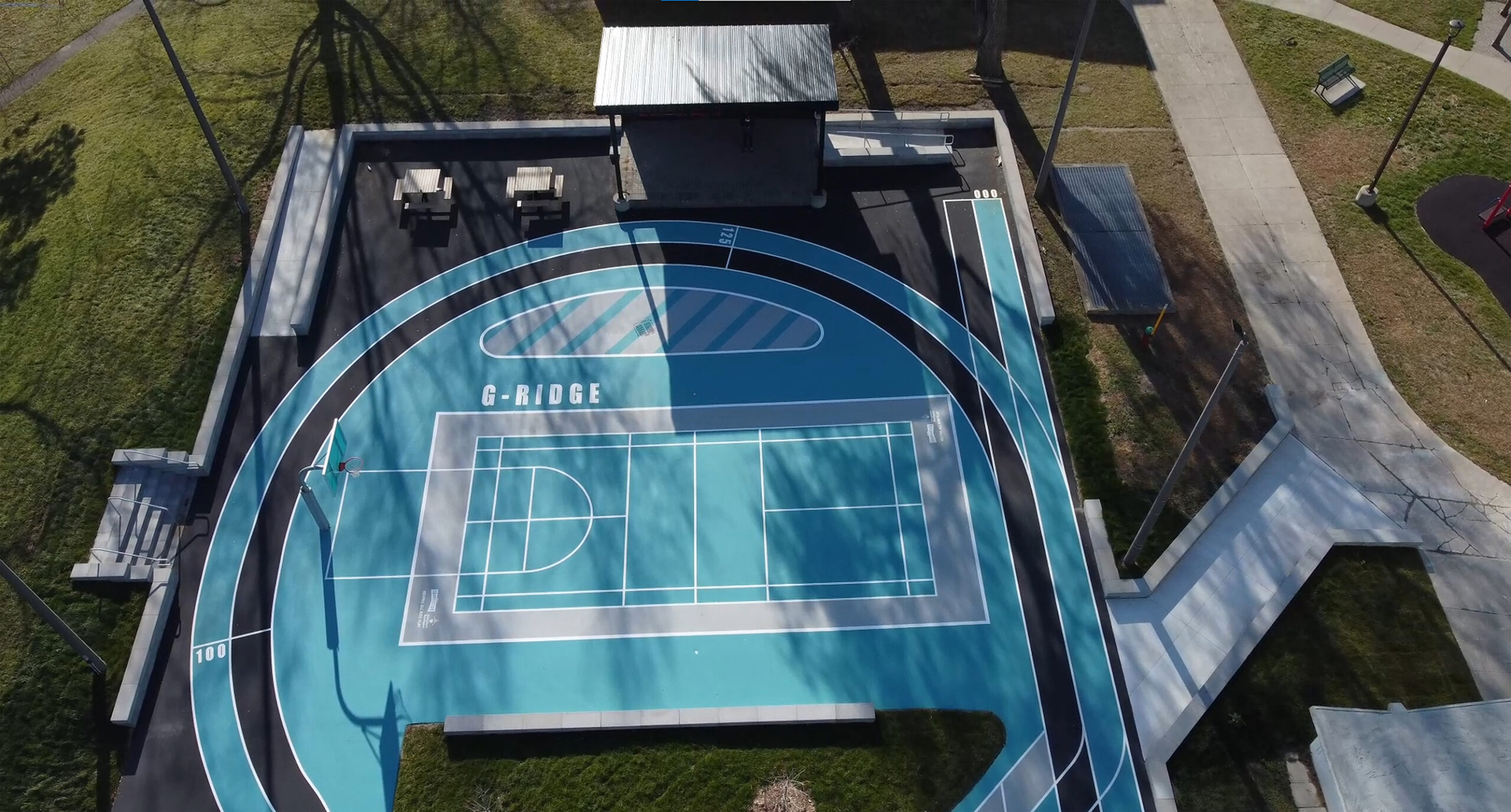 Gordonridge's court with basketball nets, seating and storage.