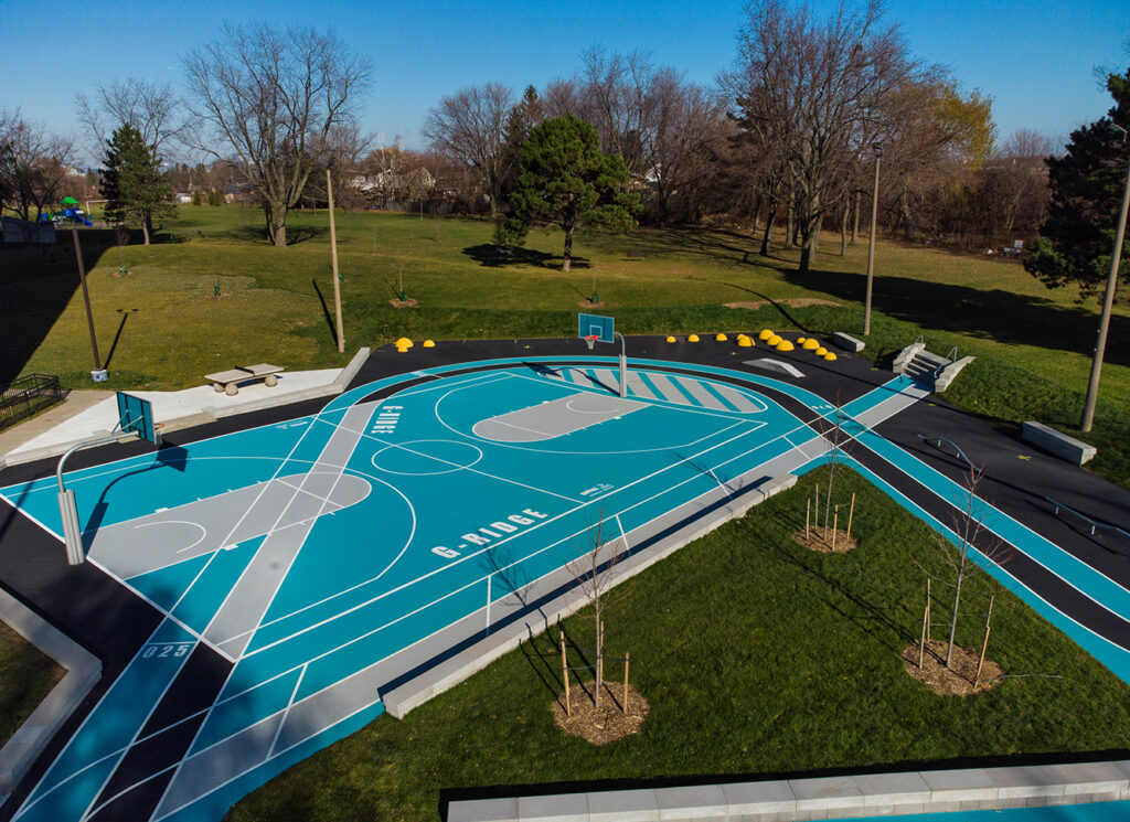 A wide view of Gordonridge's court with basketball hoops and walking track.