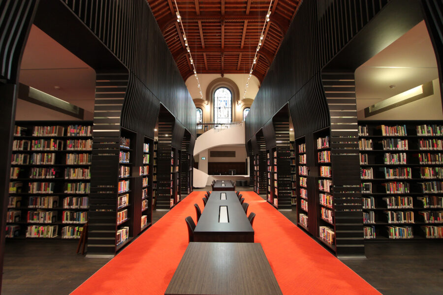 interior photo of new UC library showing stacks on left and right, with new spiral staircase centred.