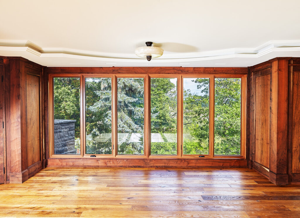 a symmetrical photo of a wide, full length window with wooden dividers. the white ceiling paneling is also visible.
