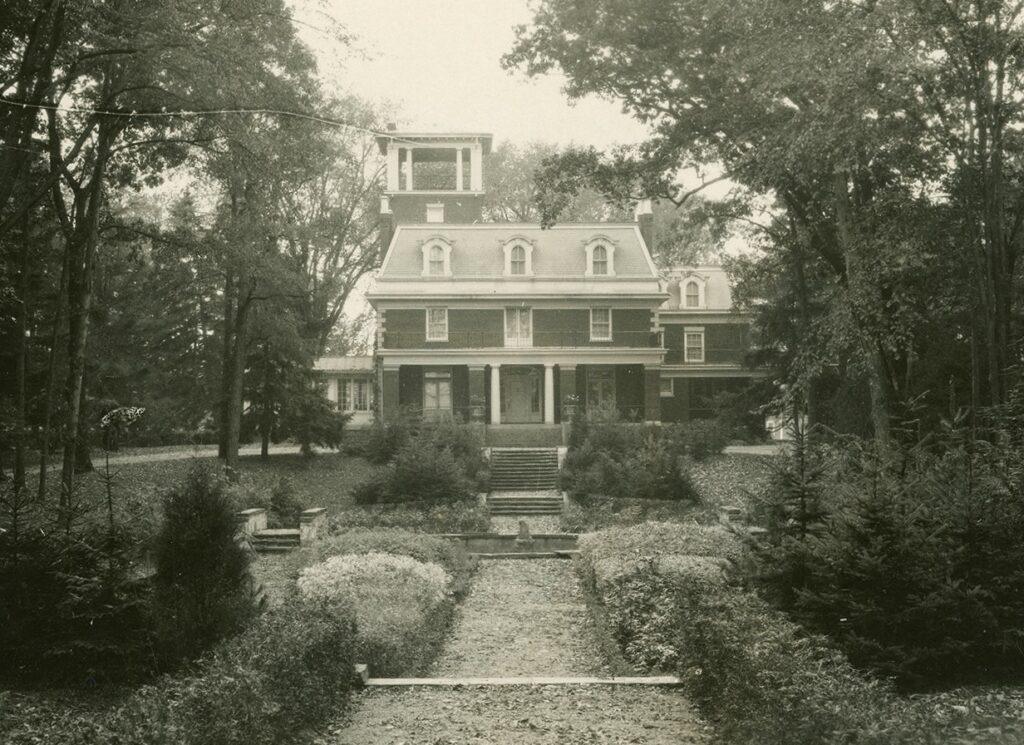 house shielded by trees, black and white photo